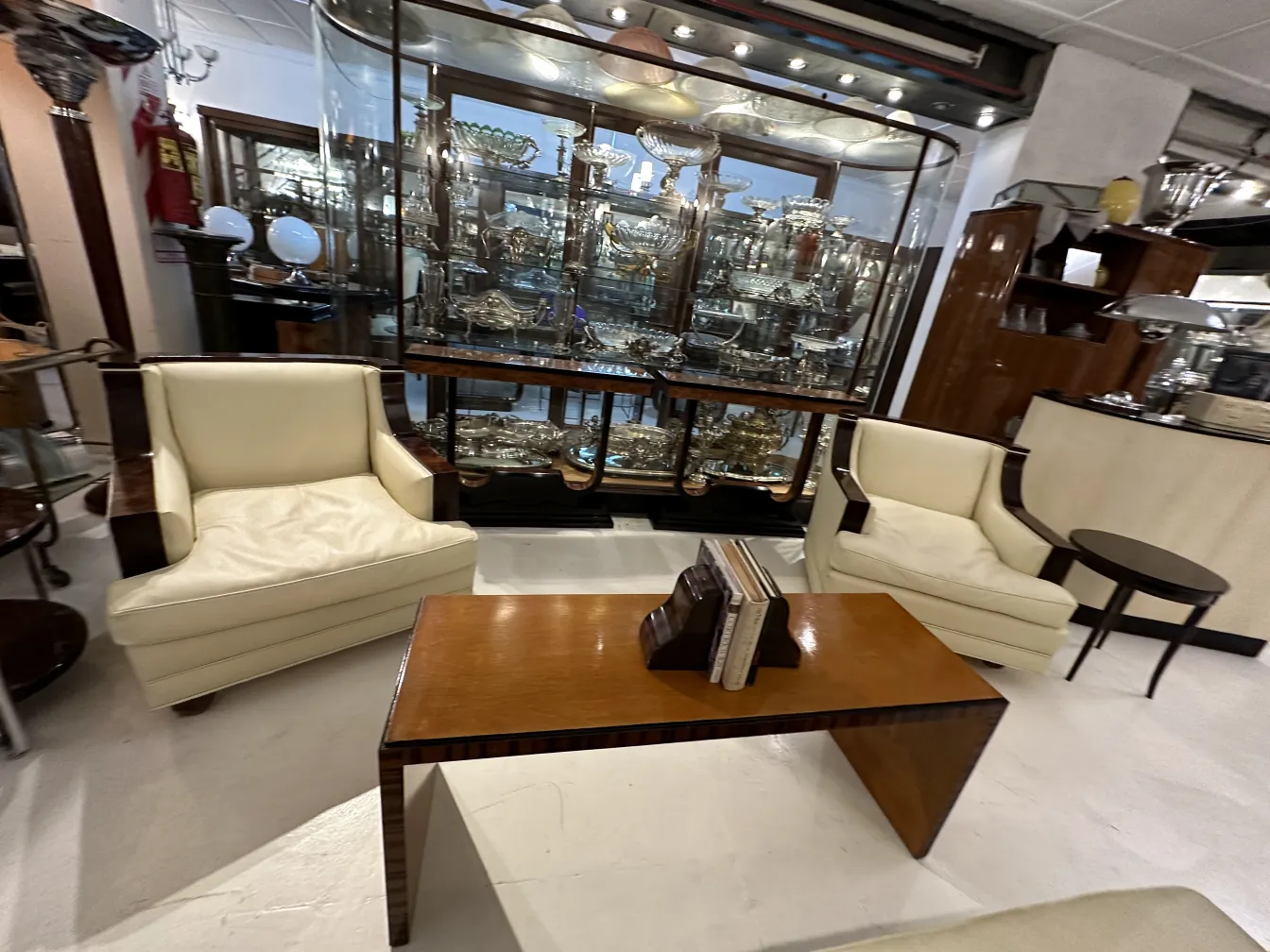 Antique decorative bookends on a table, surrounded by chairs and a display case.