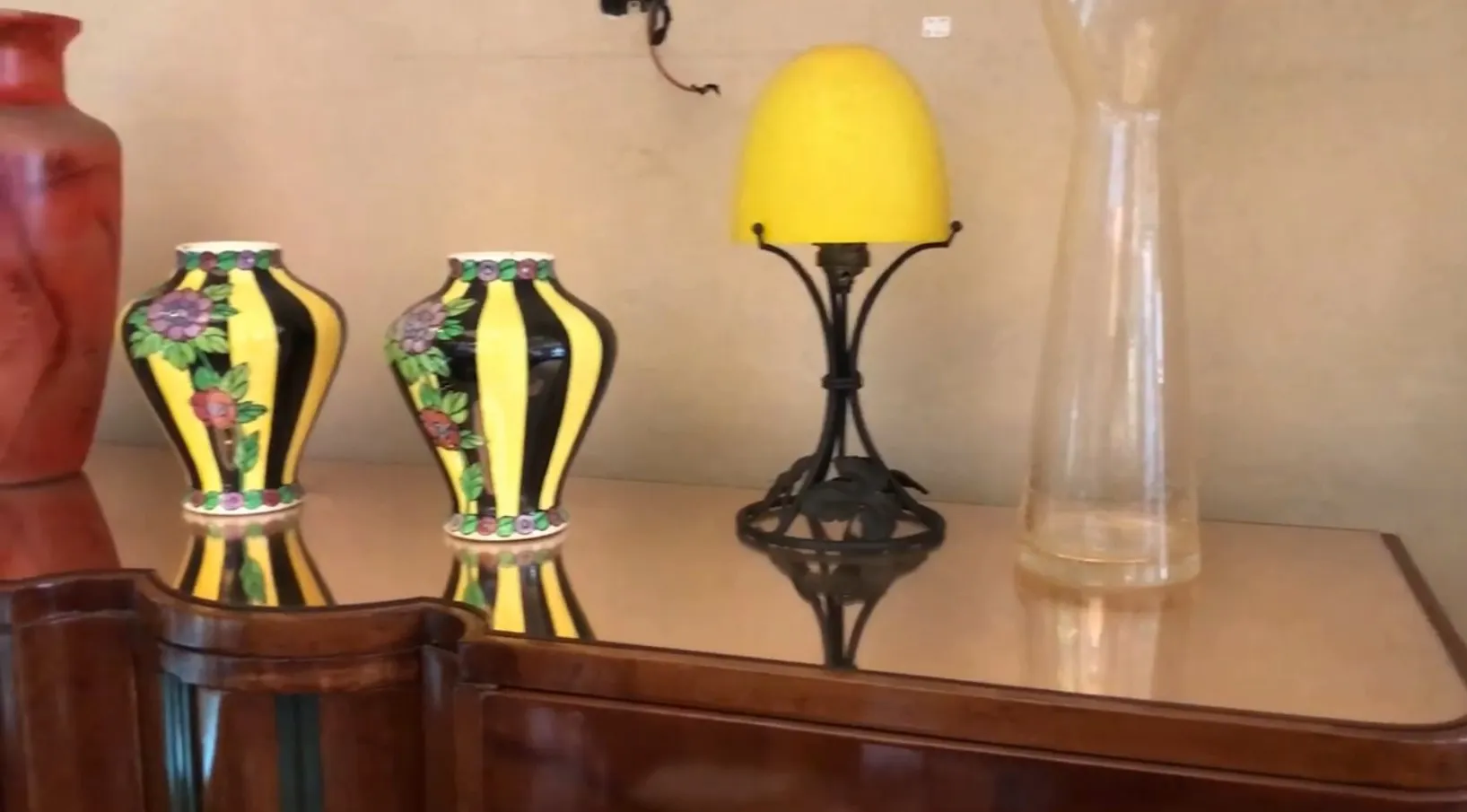 antique bookcase featuring decorative vases and lamp