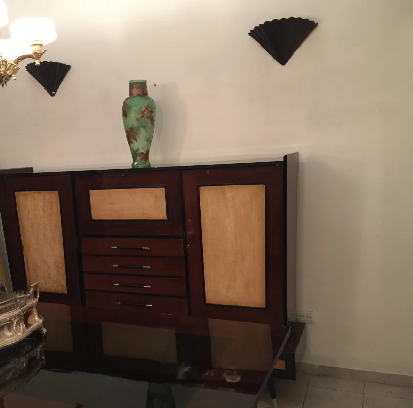 Antique bookcase with classic design and wide shelves, decorated with a vase.