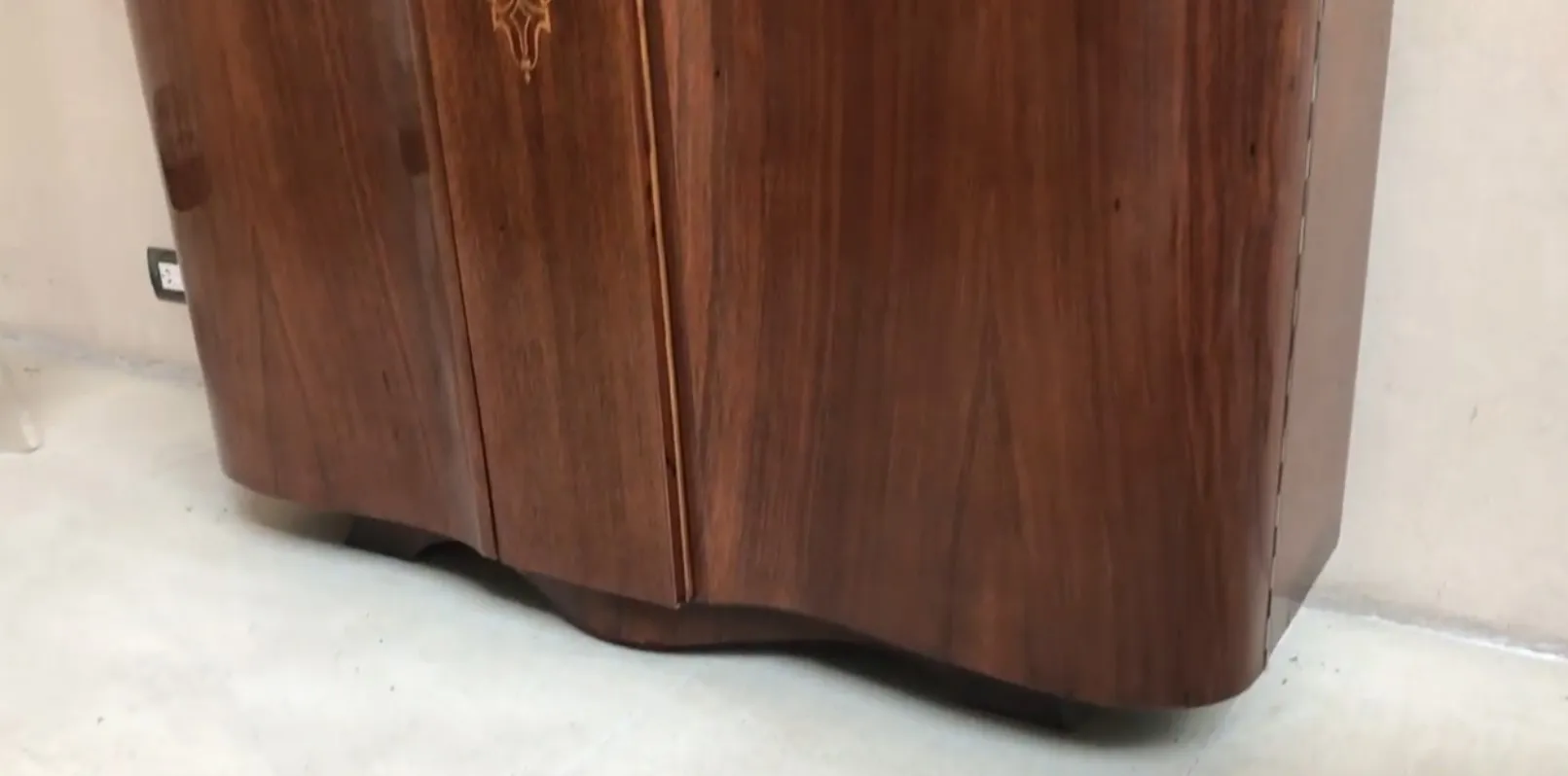 View of an antique bookcase with decorative details, neutral background.