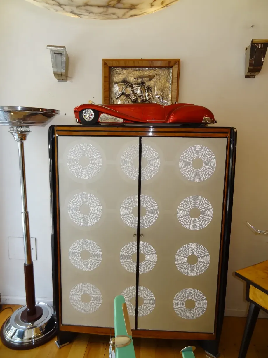 Antique bookcase with decorated doors and unique design, in a modern setting.