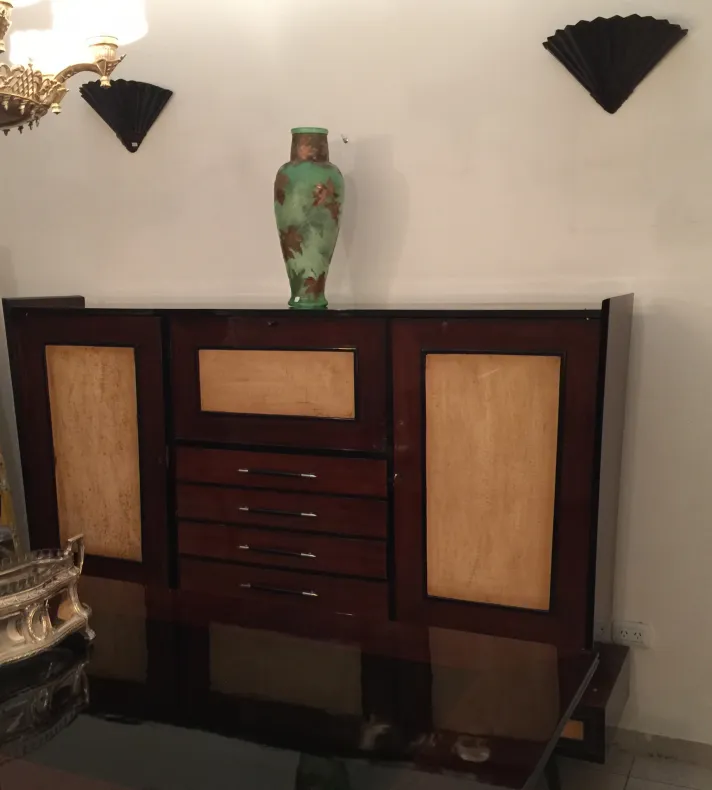 Antique wooden bookcase with decorative details and a green vase on top