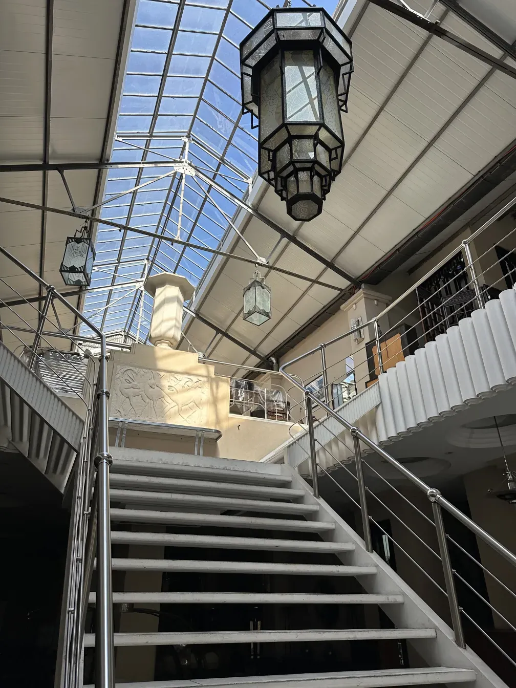 एक प्राचीन लटकता कांच का लालटेन का दृश्य एक उज्ज्वल हॉलवे में।