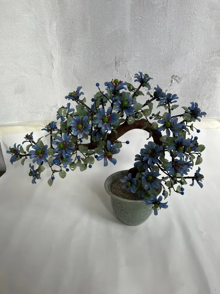 Antique bonsai with blue and red flowers in decorative pot