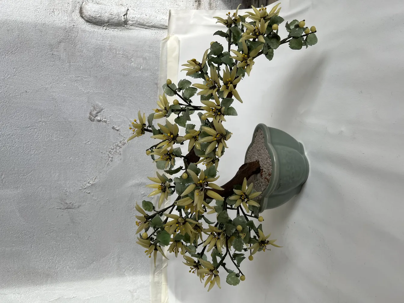 Antique bonsai in decorative green pot, with yellow flowers