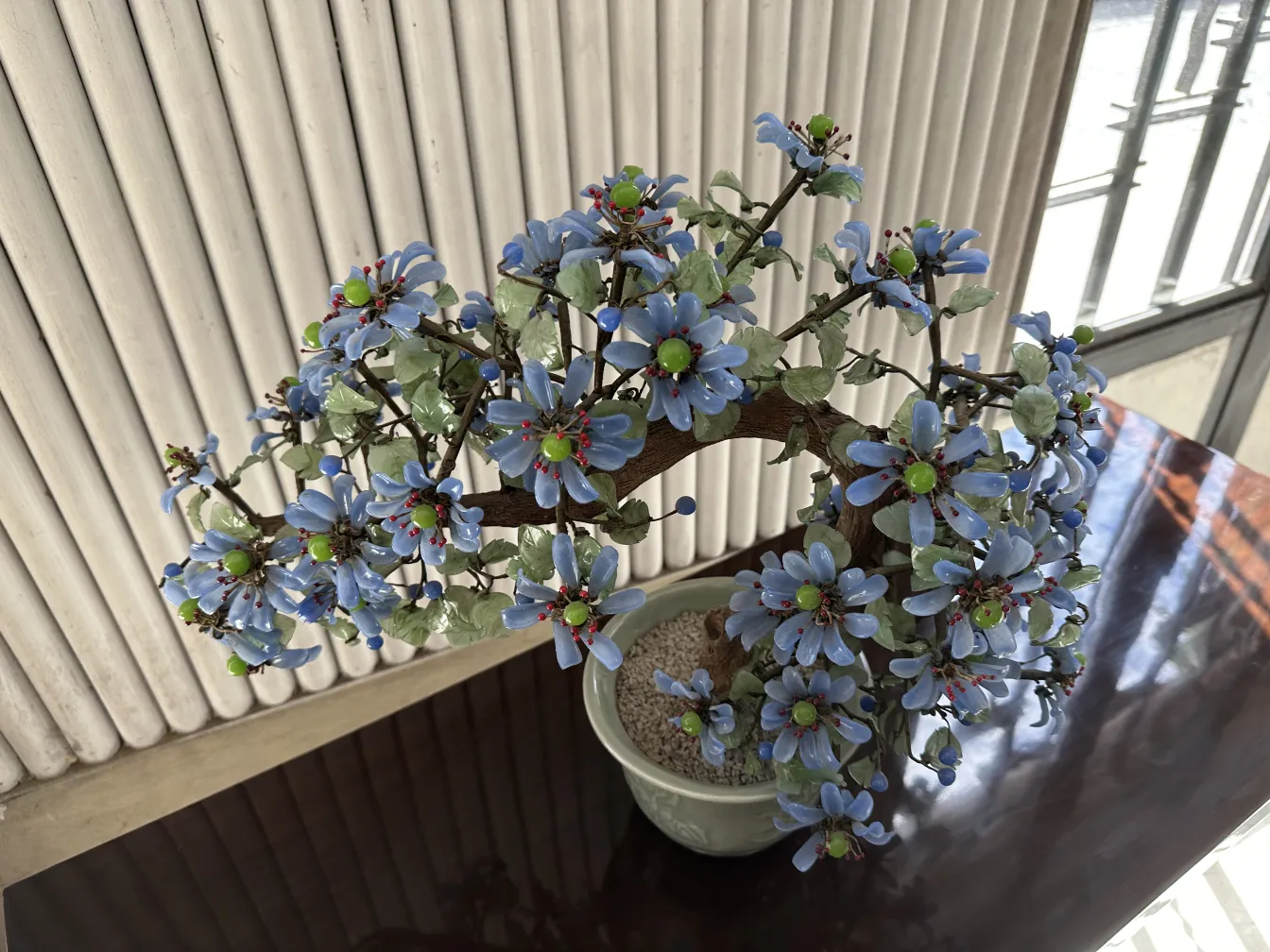 Antique bonsai with blue and green flowers