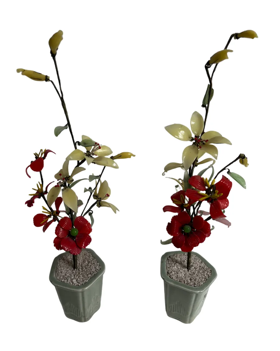 Antique bonsai with red and green flowers in gray pot.