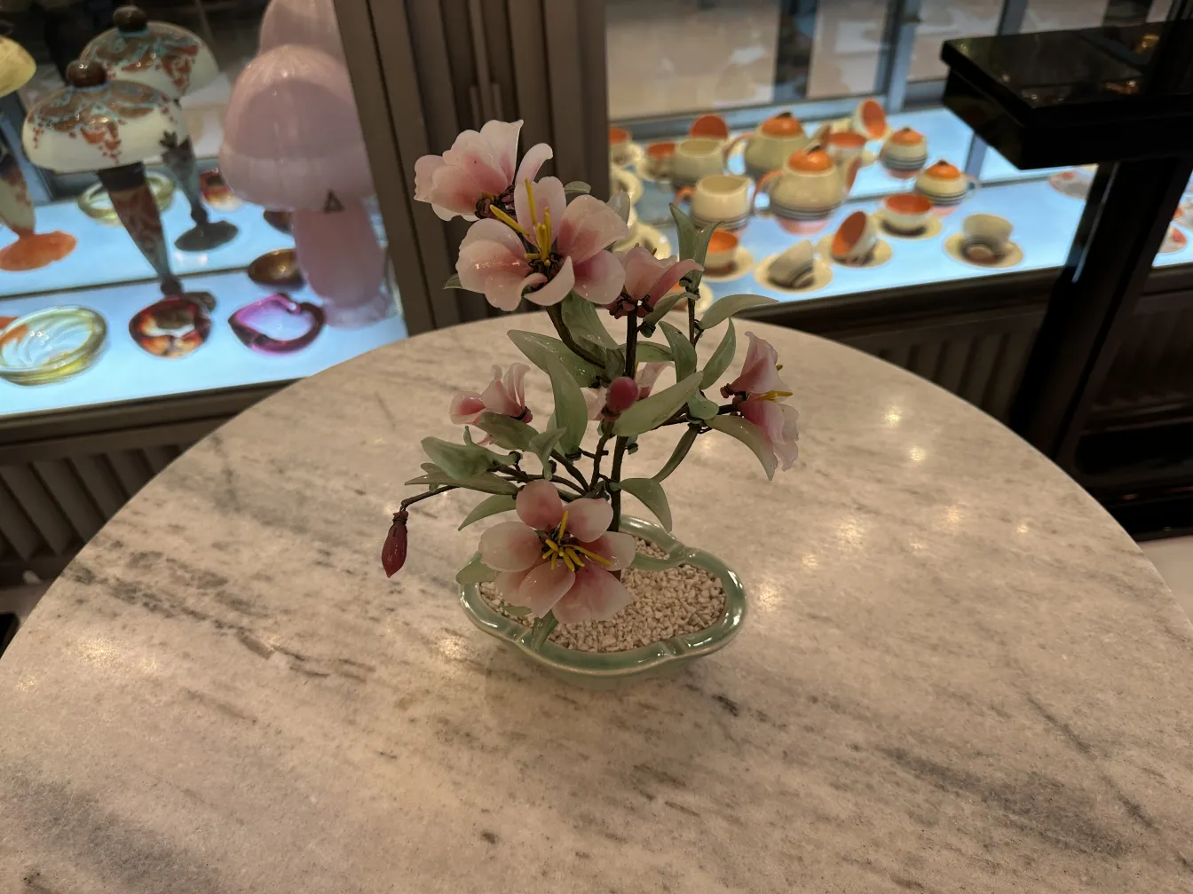 Antique bonsai with pink flowers and green leaves, decorative.