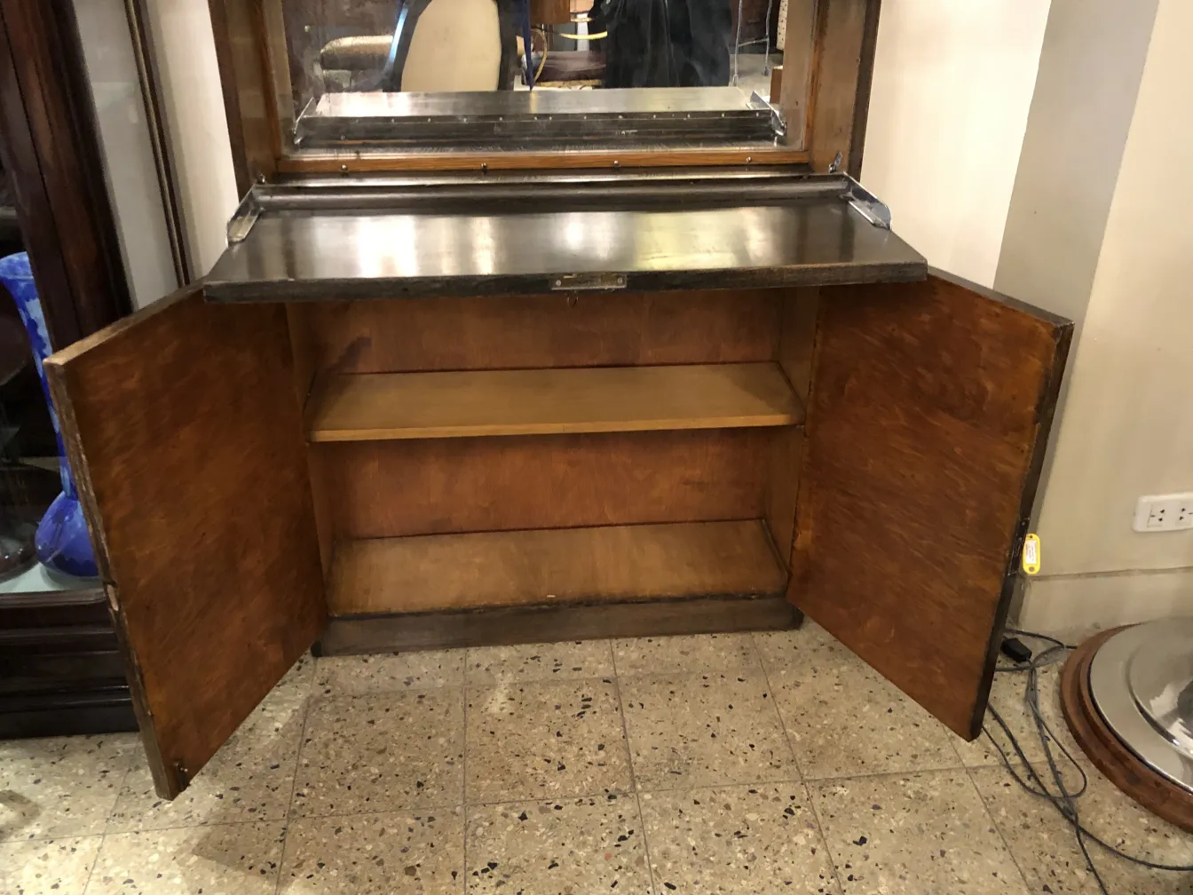 Antique bar cabinet with a mirror on top, elegant atmosphere.