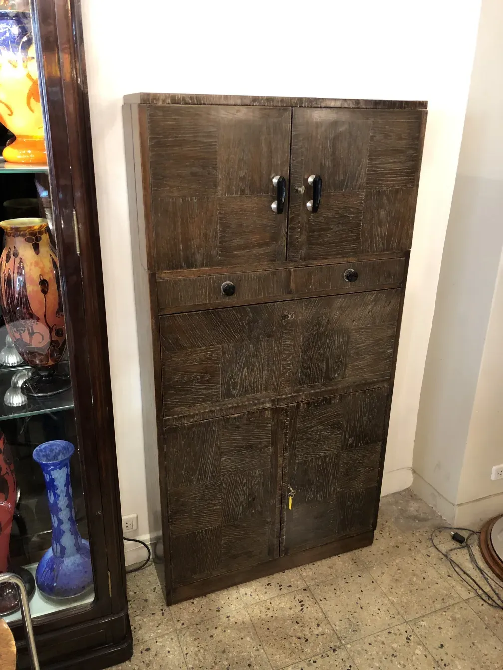 Antique wooden bar cabinet with classic design in an antique store environment.
