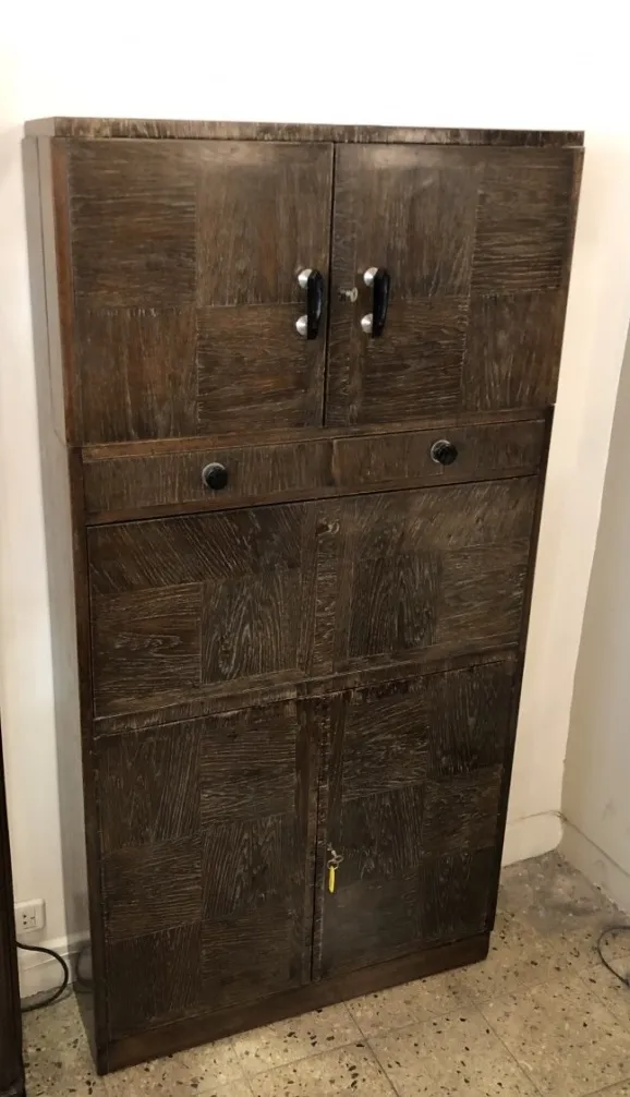 Antique wooden bar cabinet with doors and drawers.