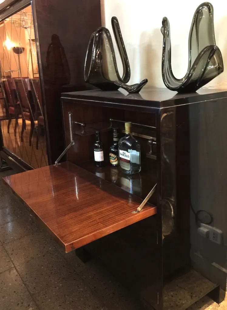 Antique bar cabinet with shiny surface and front opening.