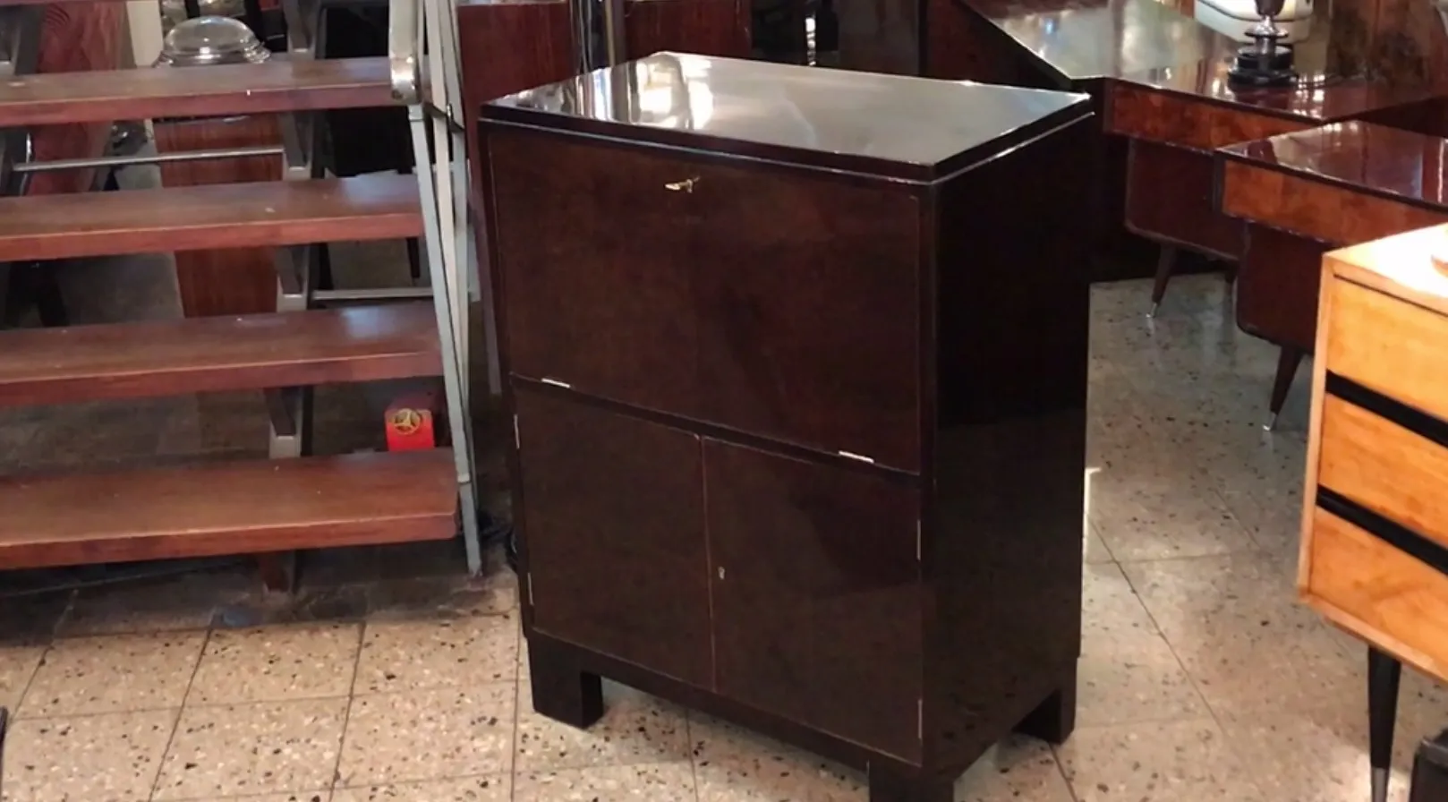 Antique bar cabinet with a glossy finish and sleek design, cozy environment with wooden furniture.