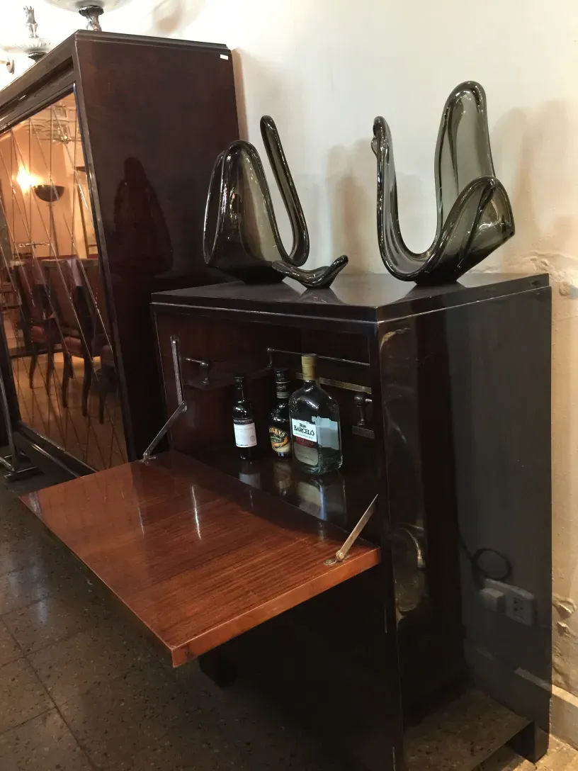 antique bar with glass background and bottles, decorative accessories on top.