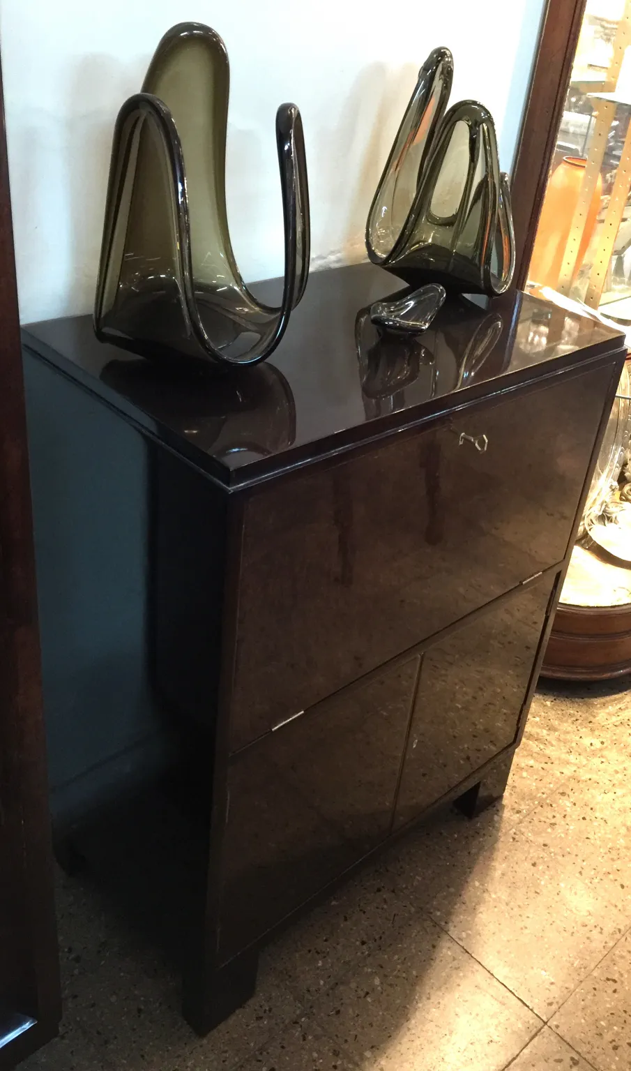 Antique bar cabinet with decorative accessories on top.