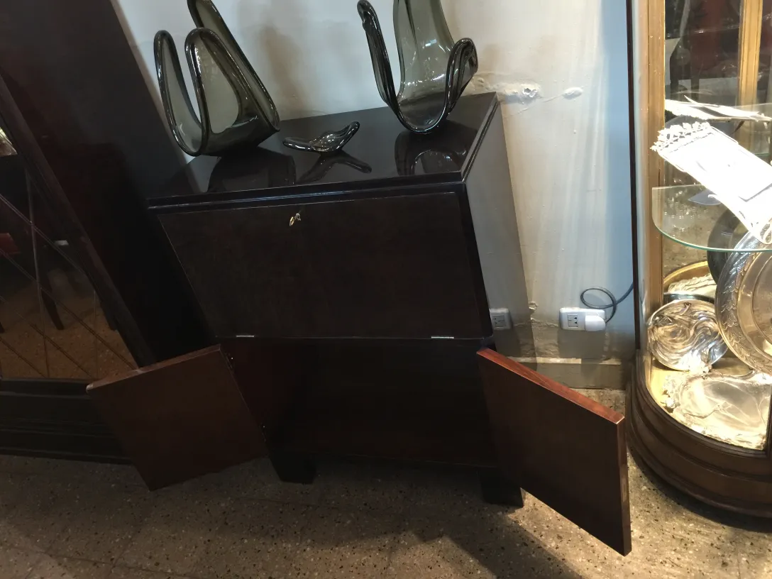 Antique bar cabinet in dark color with open doors, decorated with vases.