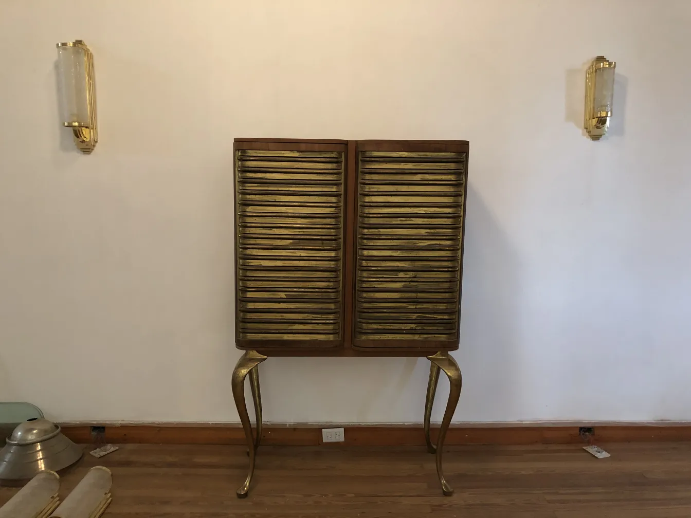 Antique bar cabinet with wood and gold finish, in a cozy setting.
