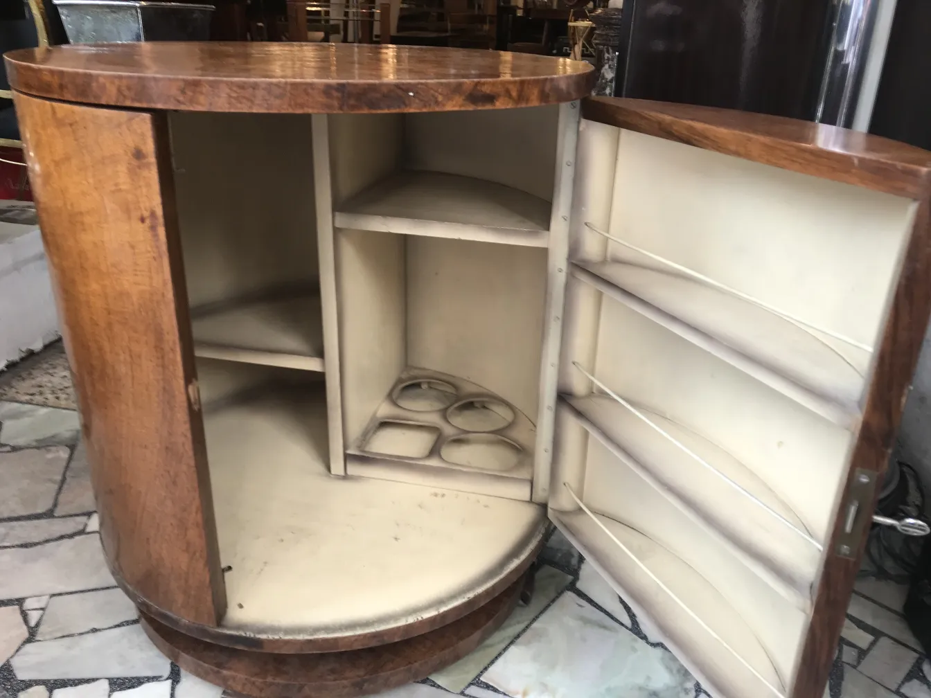 Antique wooden bar with interior storage for bottles and glasses, set in a vintage environment.