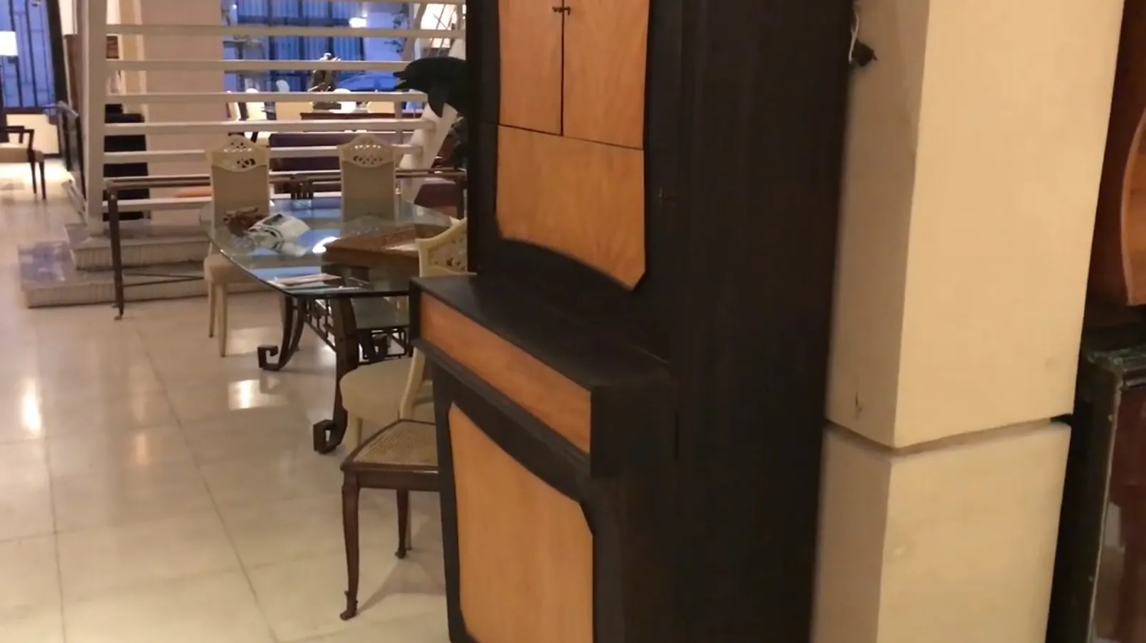 Antique bar cabinet with light and dark doors in an elegant setting.