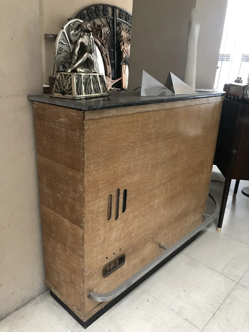 Antique wooden bar with artistic decor in the background.