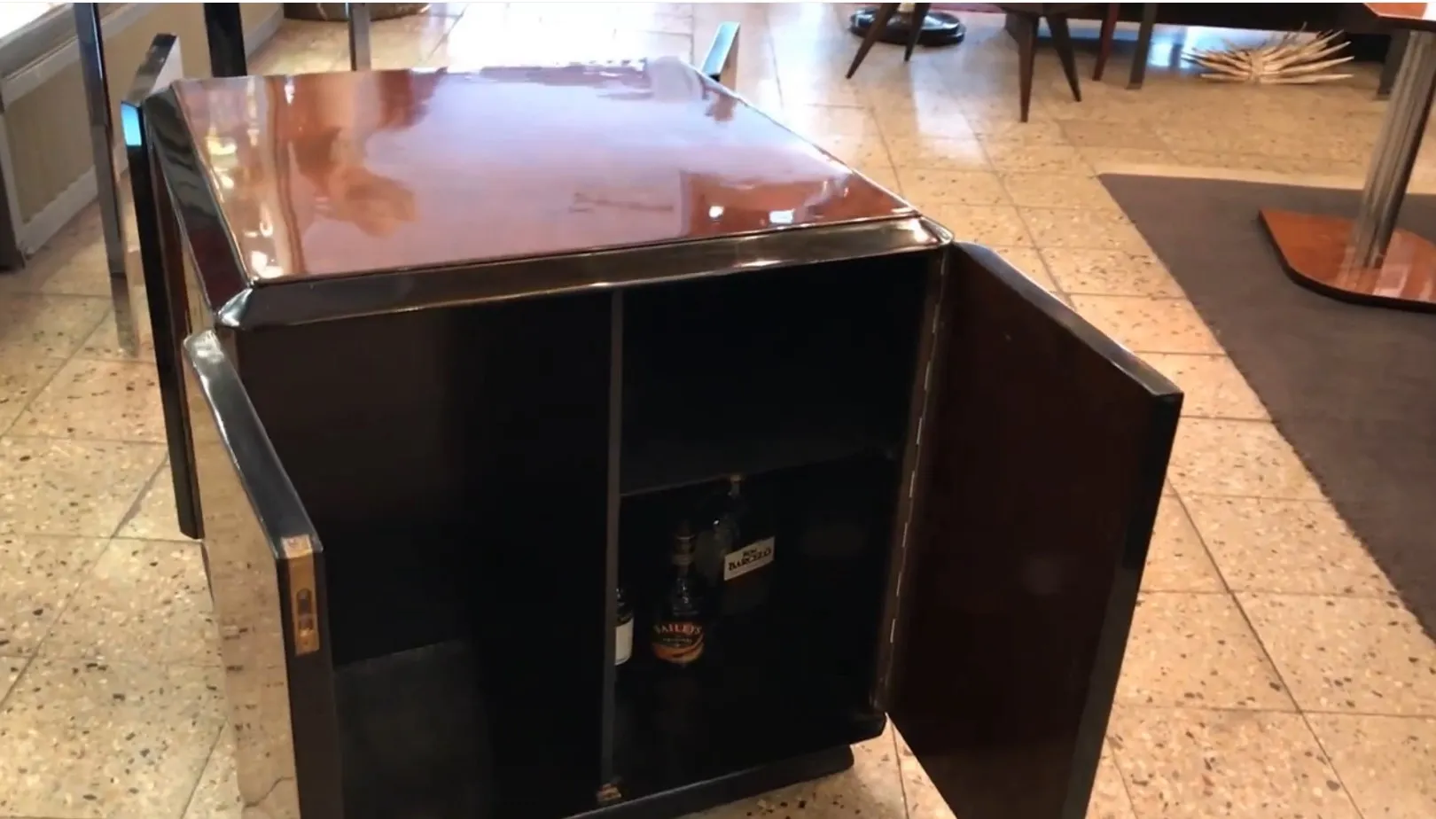 Antique bar cabinet with a sleek finish and internal storage