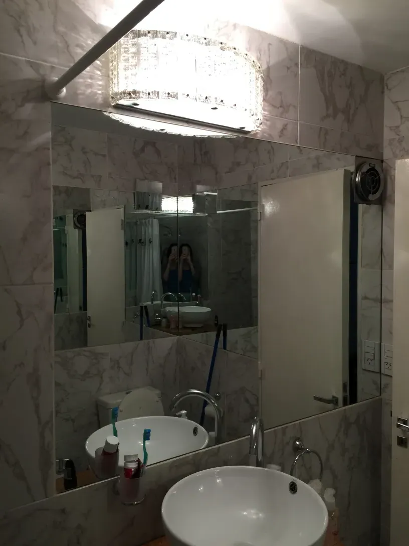 Antique sconces with decorative features in a marble bathroom