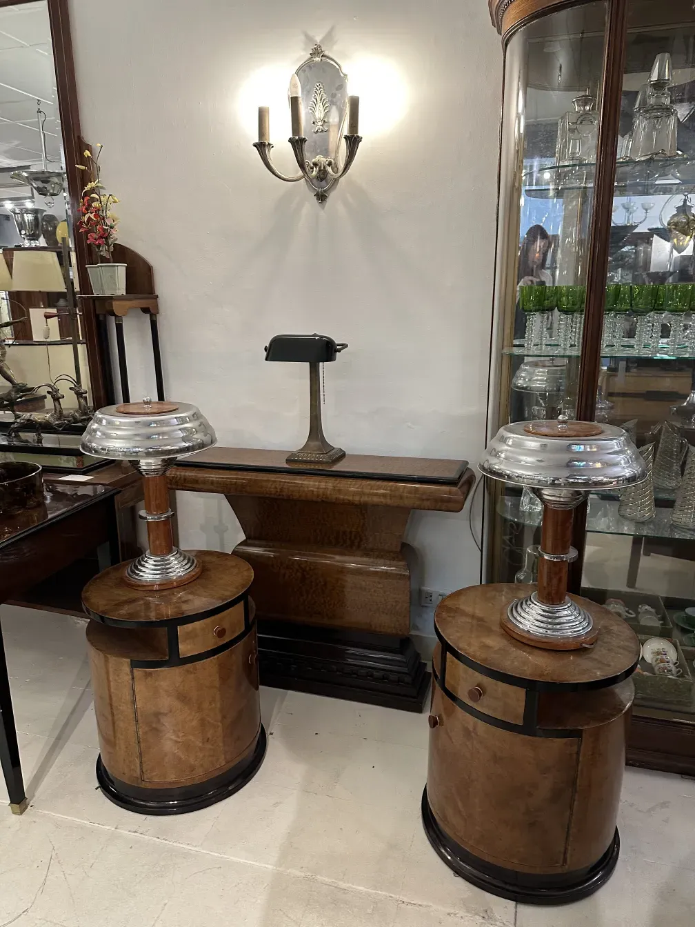 Antique pair of sconces illuminating a display case, elegant design