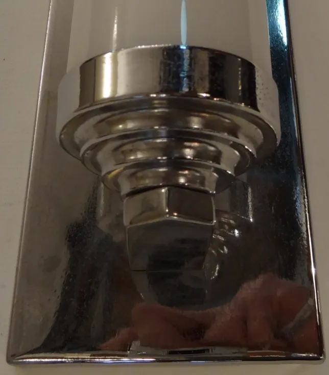 Antique pair of sconces with elegant design and shine in a cozy setting.