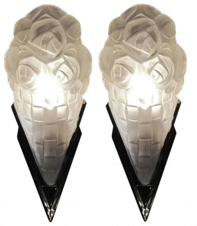 pair of antique sconces with decorative floral design, providing warm lighting.
