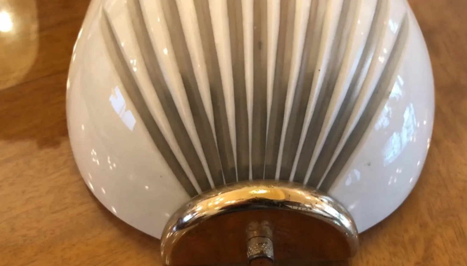 Pair of antique sconces with an elegant design, featuring a glossy finish, set on a wooden surface.