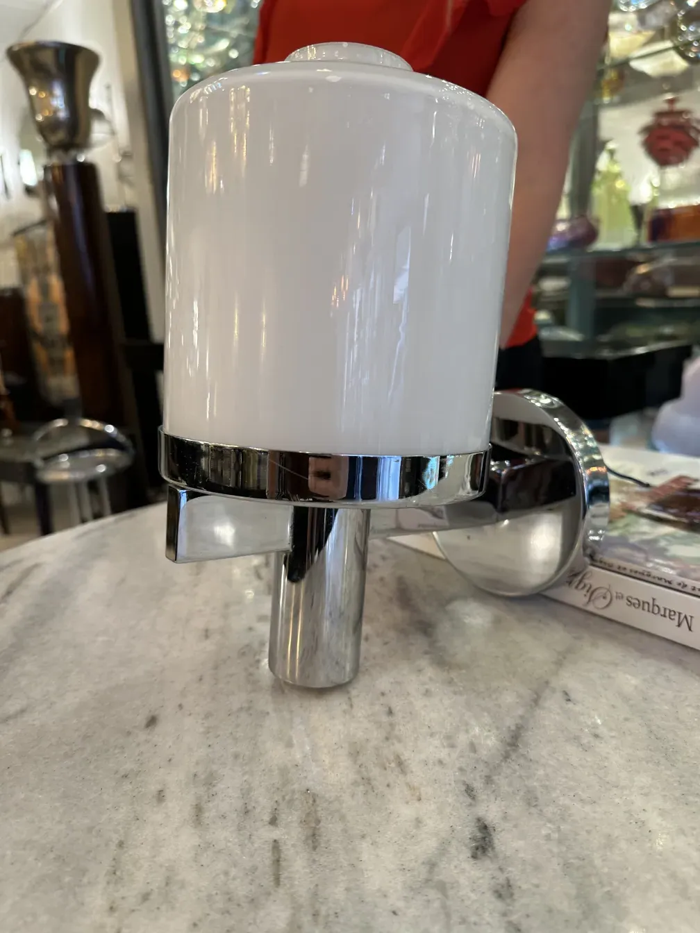 Pair of antique sconces with elegant shiny design. Seen on a marble surface.