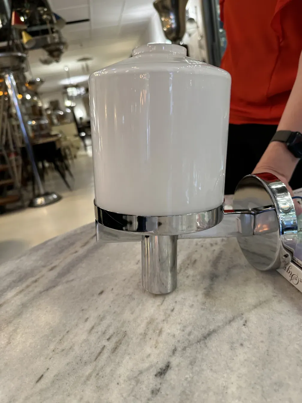 Antique sconces with shiny metal base and white ceramic shade, set in a classic environment.