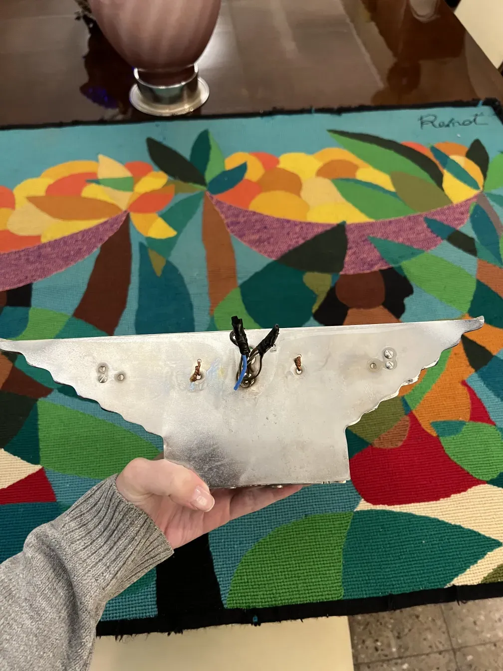 Pair of antique sconces with unique design in a colorful setting.