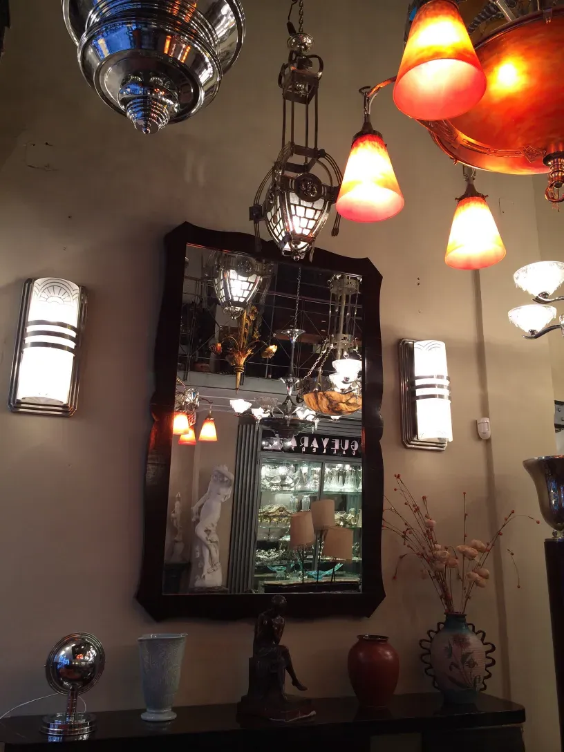 Pair of antique sconces with warm light, reflected in a mirror.