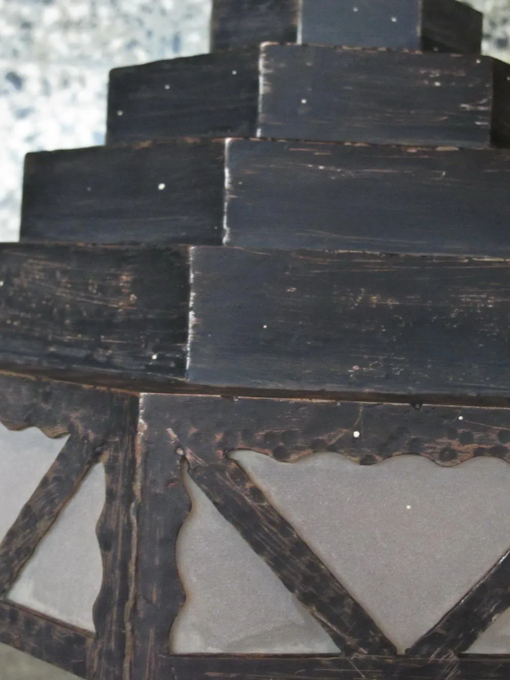 Antique sconces with decorative design and dark details against a light wall.