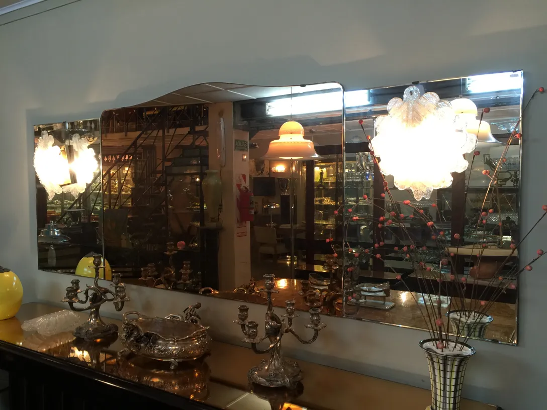 Pair of antique sconces illuminating a wall with a mirror, adding elegance to the space. Decorative design.