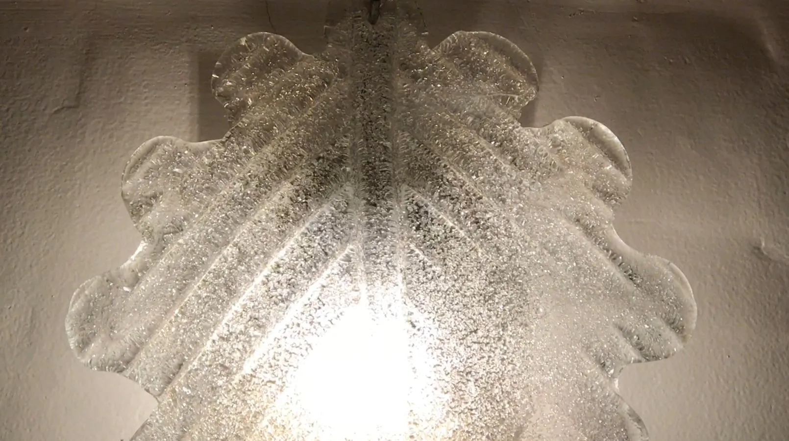 Pair of sconces glowing with soft light on a light background