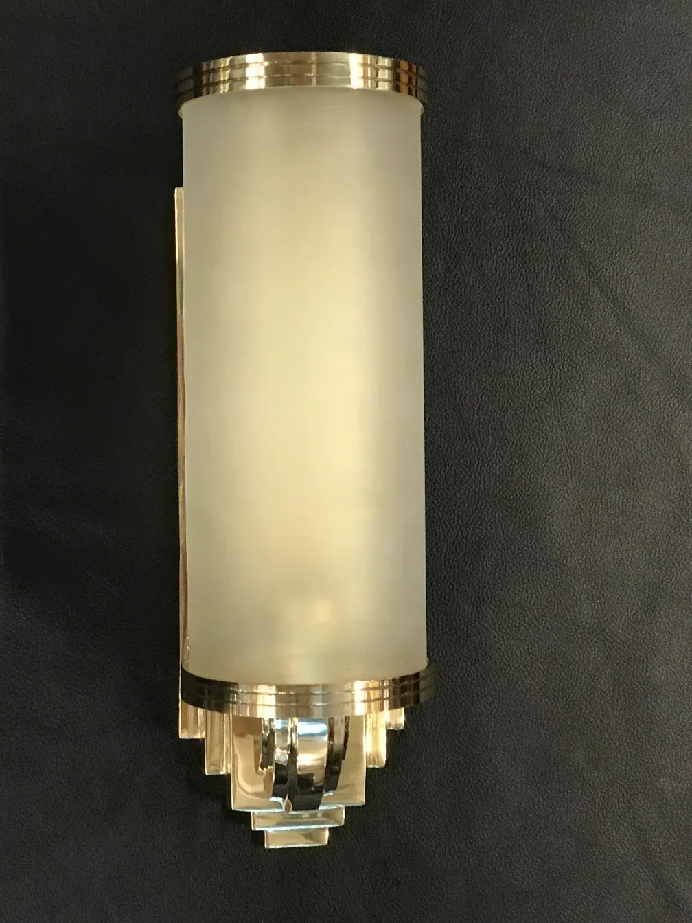 Pair of antique sconces with elegant details, dark ambiance.