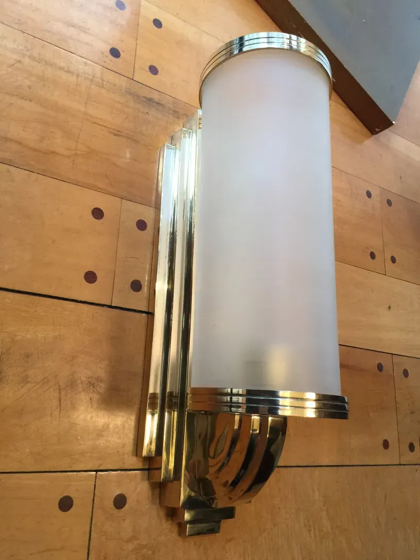 Antique pair of sconces with elegant classic design, adding light to a wooden space.