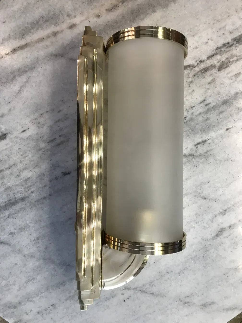 Antique wall light with elegant design and shiny finish, featuring a glass shade