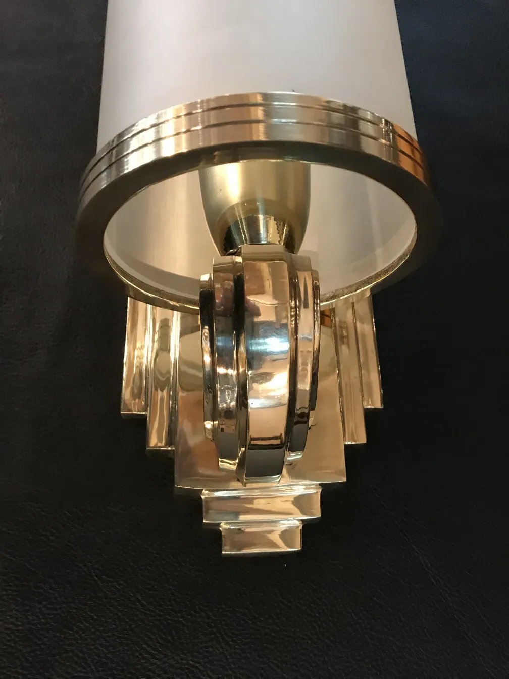 Antique wall sconces in shiny gold and white, featuring elegant design.