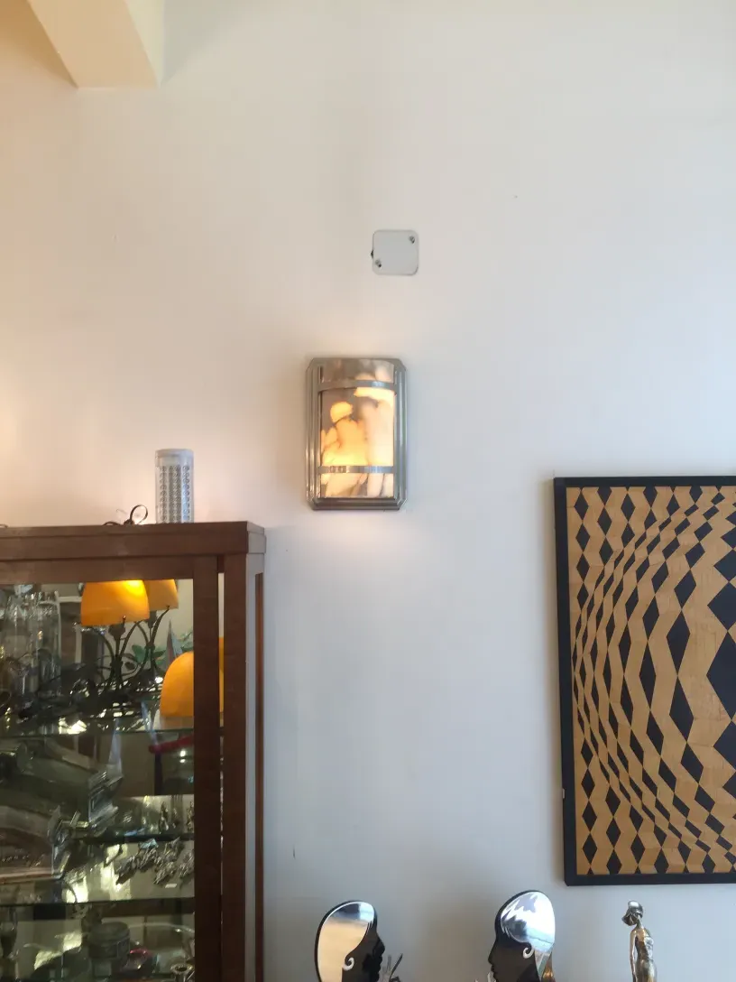 Pair of antique sconces shining on the wall, elegant decor.