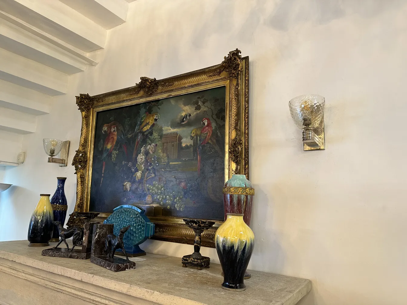 Pair of antique sconces with decorative style next to a painting