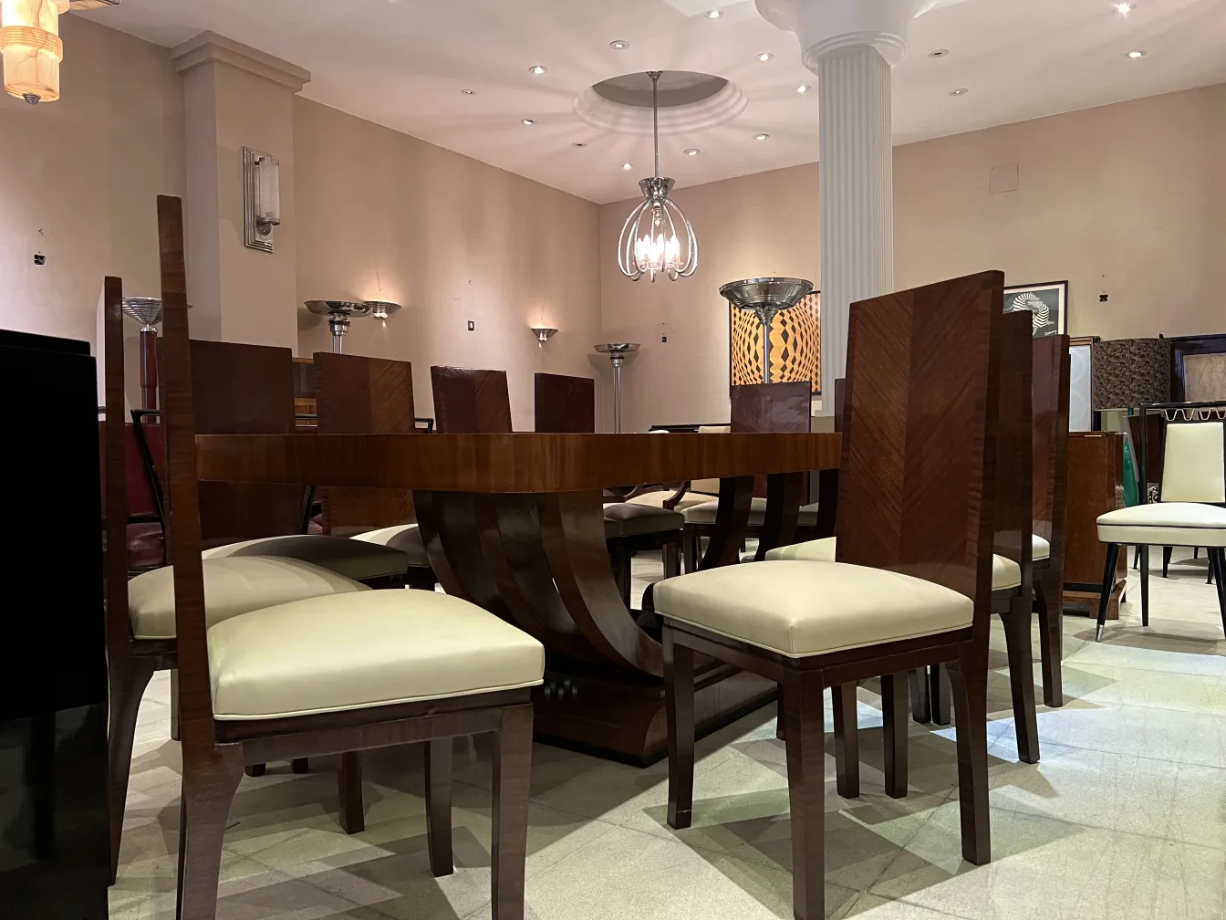 Antique pair of sconces in an elegant setting with chairs and tables.