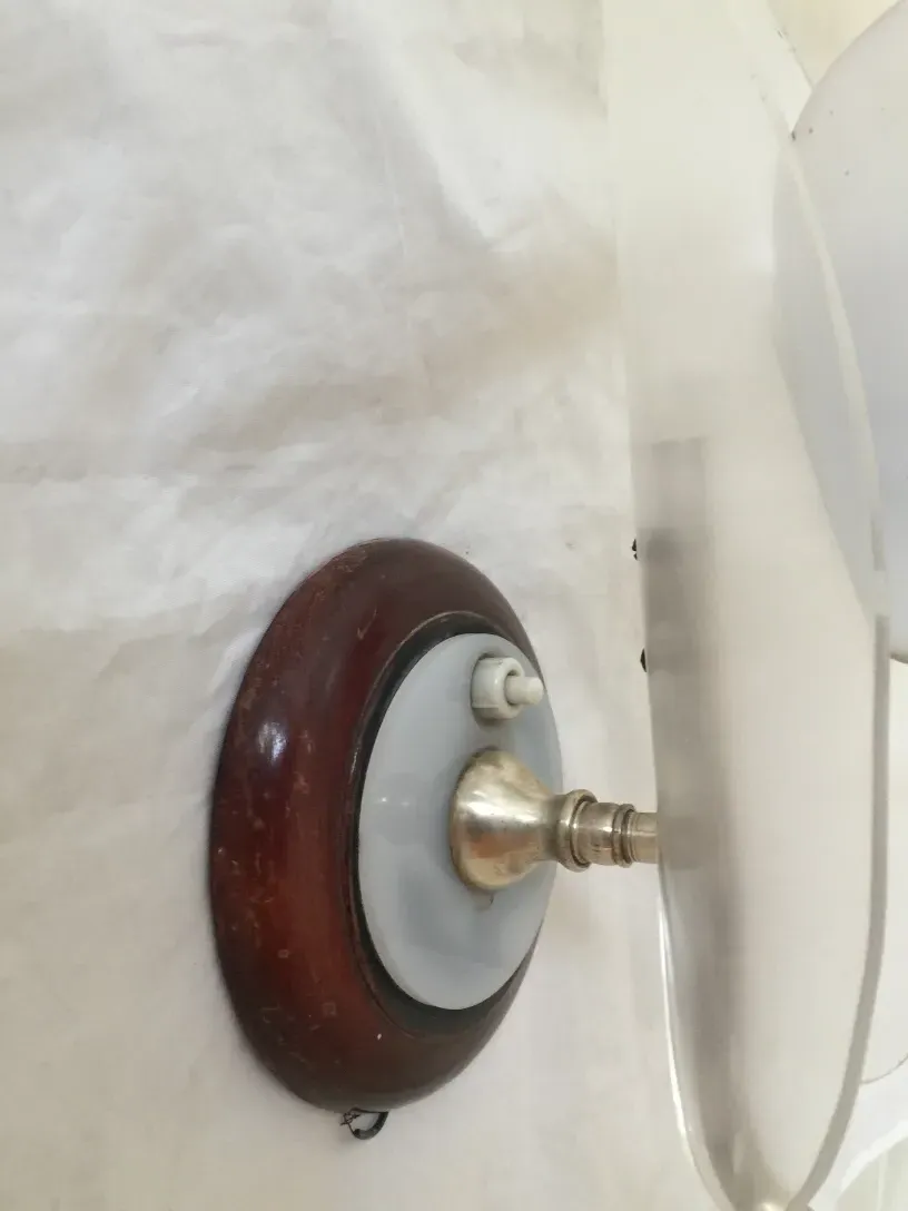 Pair of antique sconces with wooden and shiny metal base, in a cozy setting.