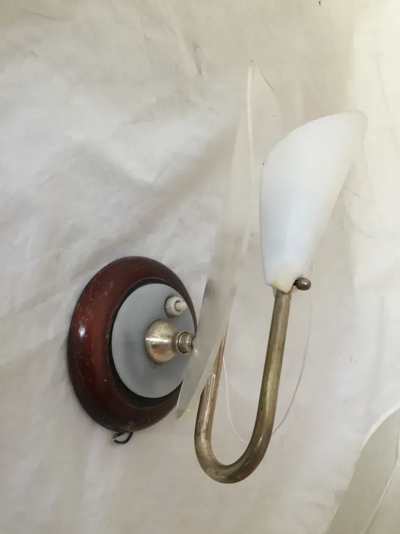 Antique pair of sconces featuring a round base and white light.