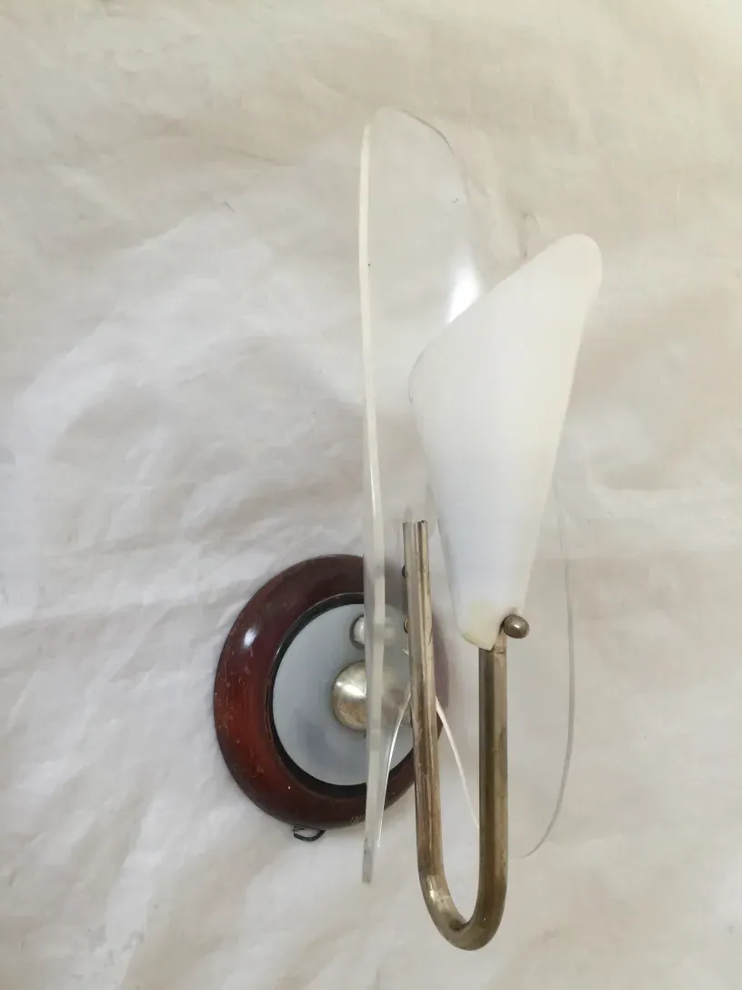 Antique wall sconces featuring white glass shades and a wooden base.