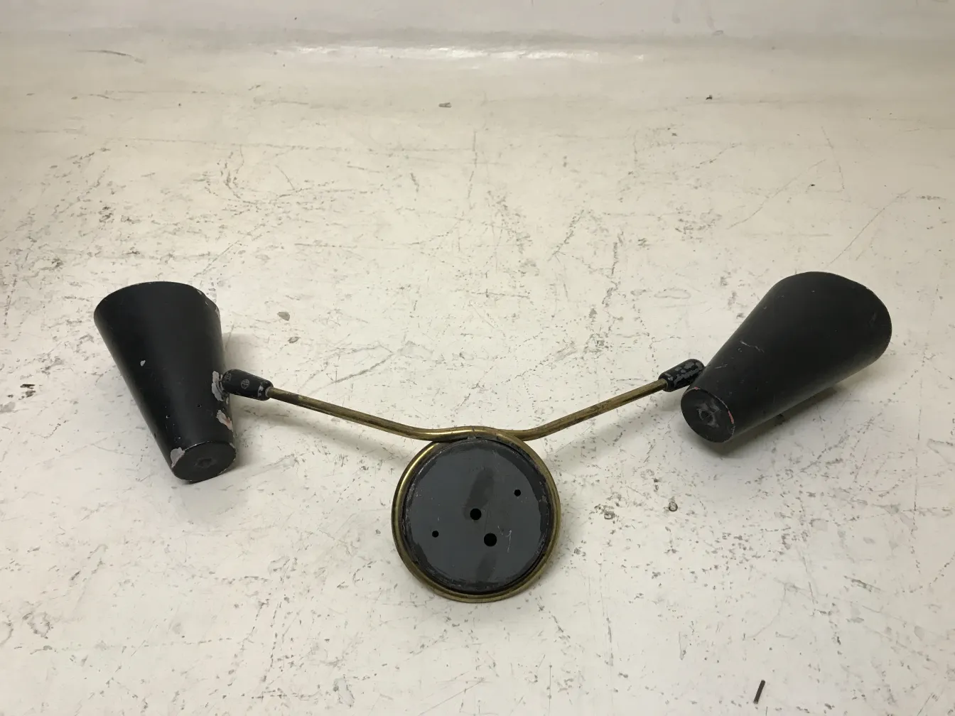 Antique sconces with two cone-shaped shades and support arms. Stand out in a retro setting.