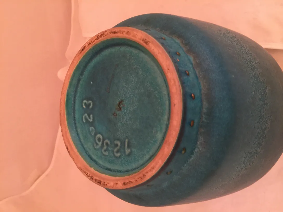 Antique blue ceramic object with intriguing details.