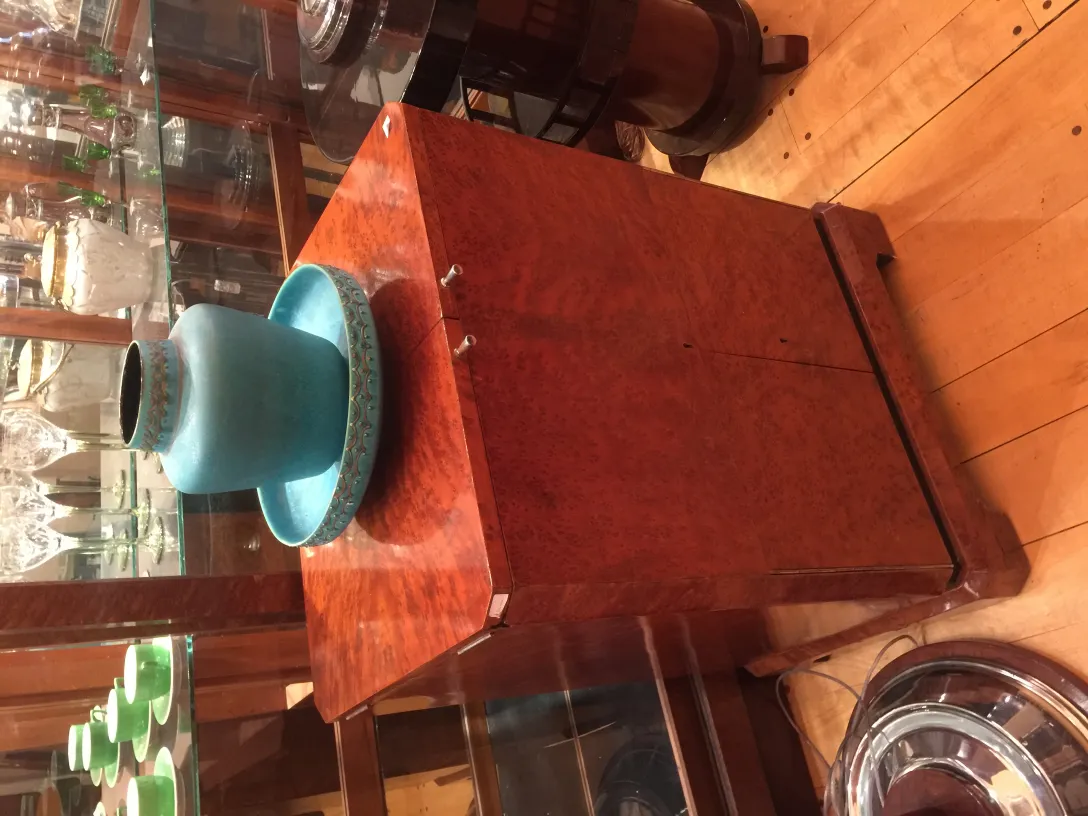 Antique ceramic of classic style with blue and green decoration, on a wooden stand.